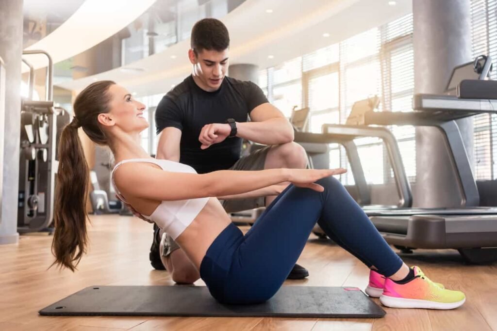 una mujer haciendo abdominales con un hombre al fondo