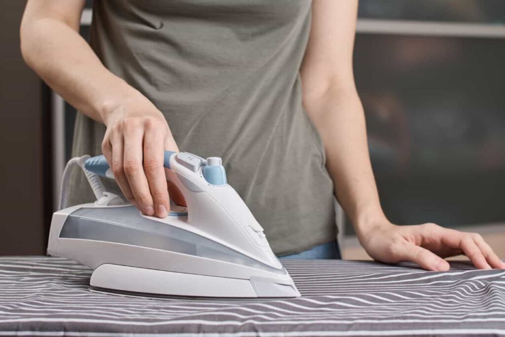 una persona planchando ropa sobre una tabla de planchar